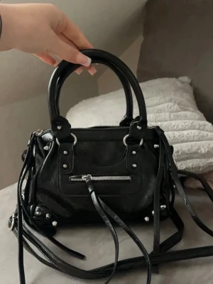 Svart handväska med dragkedja - Snygg svart handväska i skinnimitation med både handtag och axelrem.  Helt ny aldrig använt:)