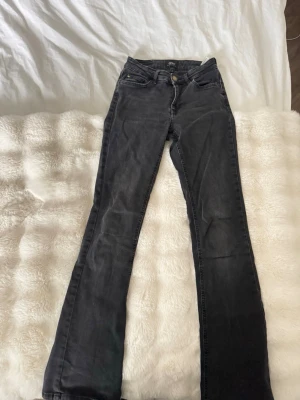 Svarta bootcut jeans  - Snygga svart/grå bootcut jeans från only med klassisk femficksmodell. Jeansen har en något utsvängd passform nedtill och är ej trasiga någonstans. Storlek S längd 32