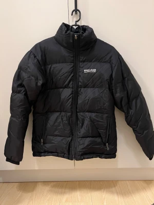 Svart pufferjacka från 8848 Altitude - Snygg svart pufferjacka från 8848 Altitude med hög krage och dragkedja framtill. Jackan är sparsamt använd. Storlek 38/M