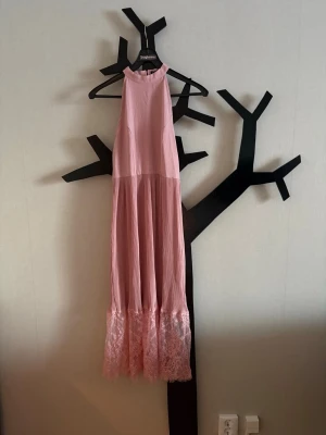 Klänning  - Ny långklänning. Spets nertill. Dragkedja baktill. Följer med ett bälte om man vill ha det till.