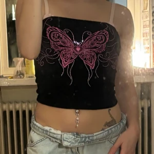 Svart tubtopp med rosa fjäril - Säljer en svart tubtopp med en stor rosa fjäril framtill och glittriga detaljer. från shein och passar xs-s