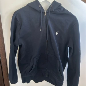 Marinblå hoodie från Polo Ralph Lauren - Marin blå raph lauren sip up, är använd men har inga defekter. Original pris 2395