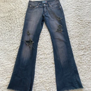 Lågmidjade bootcut jeans - Snygga lågmidjade jeans med slitningar! Säljer då dom är för små tyvärr.  Innerbenslängden - 83cm Midjemåttet - 37 cm tvärs över 