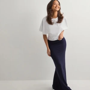 Marinblå långkjol från Nelly - Säljer en stilren marinblå långkjol från Nelly i storlek S. Klänningen har en enkel och tight passform med ärmlös design och rund halsringning. Perfekt för dig som gillar minimalistisk stil och vill ha något bekvämt men ändå snyggt.