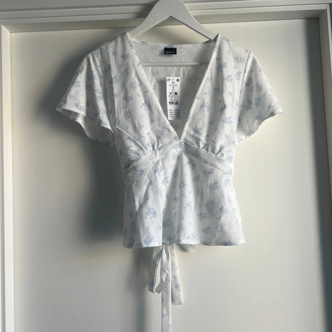 Vit blommig omlottopp från Gina Tricot