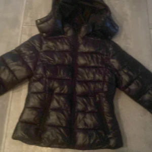 Svart pufferjacka från 157 XXS höjer pris pga köpare!! - Säljer en svart pufferjacka från 157 i storlek XXS. Jackan har huva, dragkedja framtill och är quiltad för extra värme. Perfekt för kyliga dagar och har en stilren look som funkar till det mesta.