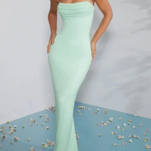 Mintgrön axelbandslös långklänning - Superfin mintgrön långklänning med figurnära passform och axelbandslös design. Klänningen har en små glittriga stenar och en snygg slits bak för extra rörelsefrihet. Perfekt för dig som vill sticka ut med en fräsch och modern look. Har använt den bara 3 timmar och aldrig mer. Passar perfekt till bröllop, bal osv. Jag är en S och köpte den från ohpolly hemsida då det är en annan typ av storlek tror det va storlek 6 men oasssr perfekt till storlek xs/s 