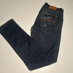Nudie Jeans Lean Dean blå jeans 29/32 - Snygga Lean Dean jeans från Nudie Jeans i mörkblå tvätt med klassiska orange sömmar och femficksdesign. Modellen är slim med en snygg tvätt. Hör av dig vid minsta lilla fundering‼️🙌🏼 pris kan såklart diskuteras!🙌🏼 säljs för 499 eftersom tvätten är dry