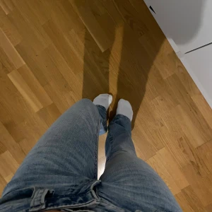 Ljusblå bootcut jeans från Gina Tricot - Säljer ett par ljusblå jeans från Gina Tricot med bootcut passform och låg midja. Jeansen har klassiska fickor med lock och knapp bak, samt snygga sömmar och bälteshällor. Sälja pga de är för långa☺️
