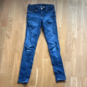 Blå low waist jeggings från &Denim - Säljer ett par blå jeggings från &Denim i storlek 26/30. De har låg midja, klassiska jeansfickor och smal passform hela vägen ner. Materialet är stretchigt denim som sitter tajt och bekvämt. Perfekta för dig som gillar skinny jeans-look!