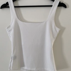 Vit linnetopp från SHEIN - Säljer en stilren vit linnetopp från SHEIN i storlek S. Toppen har breda axelband och en fyrkantig halsringning som ger en clean look. Materialet är mjukt och stretchigt, perfekt för varma dagar. Enkel att matcha med jeans eller kjol.