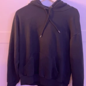 Svart hoodie med huva och ficka - Svart hoodie med huva och snörning.