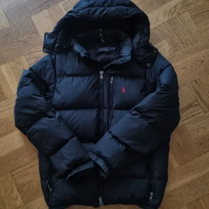 Ralph Lauren jacka herr - Stilig Ralph Lauren vinterjacka i svart, i storlek M. Jackan är nästan i nyskick, med en tidlös design som håller dig varm och snygg under hela vintersäsongen. För fler frågor är det bara att skriva!!🤗