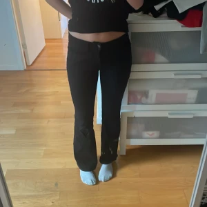 Svarta jeans från Lindex - Säljer ett par svarta bootcut-jeans från Lindex, modell Freja, i storlek 158/164. Byxorna har medelhög midja, klassiska bakfickor och dragkedja med knapp framtill. Materialet är mjukt och stretchigt. De är jättesköna och bekväma, sparsamt använda, inget tecken på användning. 