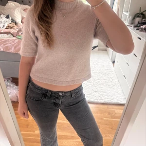 Beige stickad topp från  & Other Stories - Superfin beige stickad topp från & Other Stories med croppad passform och korta ärmar. Mjuk och mysig med ribbad halsringning, perfekt till jeans eller kjol. Enkel och stilren design som funkar året runt.