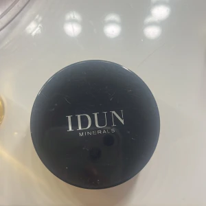 IDUN Minerals Foundation Freja 036 - Mineralfoundation i nyansen Freja 036 från IDUN Minerals. Färgen är warm light/medium och produkten är i puderform. Kommer i en rund svart burk med lock. Vegansk och innehåller SPF 15. Perfekt för en naturlig bas. Den är använd ett par gånger men den har mycket produkt i såg fortfarande 