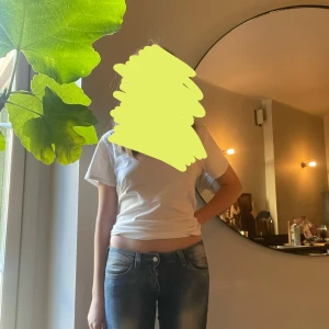 Blå bootcut jeans med tryckt patch - Säljer ett par blå bootcut jeans från Cheap Monday med låg midja och snyggt slitna detaljer. Jeansen har en vit och svart tryckt patch bak i midjan och klassisk femficksdesign. Materialet är stretchigt denim som sitter skönt och följer kroppen. Köpte de för 400kr men kommer sälja för 350