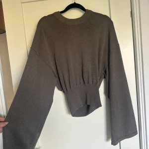 Brun stickad tröja från Gina Tricot - Säljer en brun stickad glittrig tröja från Gina Tricot med bred resår i midjan och vida ärmar. Tröjan har rund halsringning och är i en mjuk, skön kvalitet som passar perfekt till lager-på-lager. Enkel att styla till både jeans och kjol.