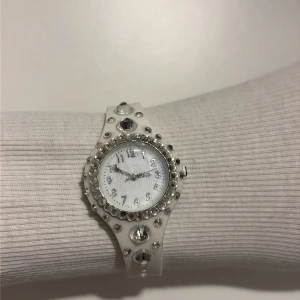 Vit klocka med stenar från Rubicson - Snygg vit klocka från Rubicson med silikonarmband och glittriga stenar runt urtavlan och på bandet.  Bling 🩵🤍