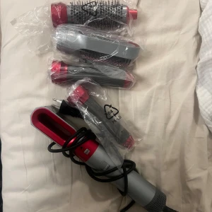 Hot air styler hårfön - Hårfön med flera stylingtillbehör, alla i nyskick och fortfarande i plastförpackning. Perfekt för att skapa lockar, volym och släta frisyrer utan extrem värme. Enheten och tillbehören ser oanvända ut och är i utmärkt skick.