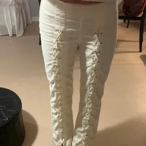 Vita byxor med snörning & Other Stories - Snygga vita byxor från & Other Stories med cool snörningsdetalj längs båda benen. Mycket bra skick! Nypris var ca 850