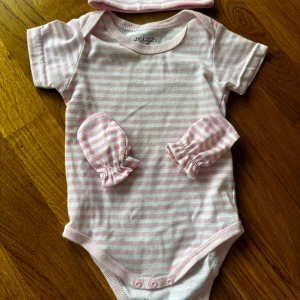 Body med vantar och mössa - Fin rosa randig body med matchande mössa och vantar😍 storlek 3-6 månader