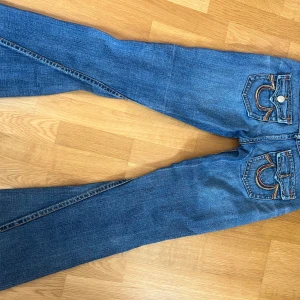 Low waist bootcut true religion  - Vintage Low waist bootcut true religion jeans med brodering på bakfickan. Jag är 170 och brukar ha storlek 36/S
