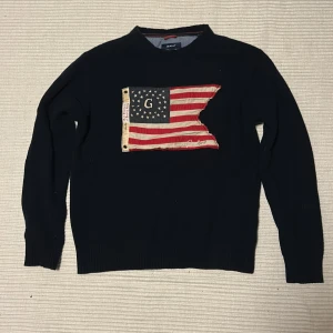 Svart stickad tröja från Gant med flagga - Säljer Mörkblå gant tröja då den är för liten. Är i storlek L men passar M! Va inte rädda för att ställa frågor!!