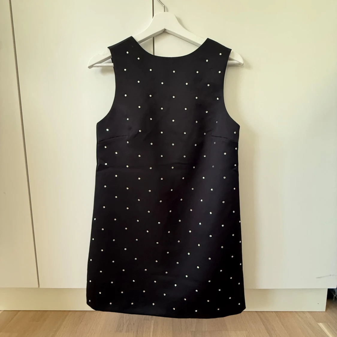 Svart kort klänning med paljetter på och en rosett i ryggen