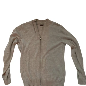 Beige kofta med dragkedja från Stenströms - Beige kofta med dragkedja framtill och ribbade muddar vid hals, ärmslut och nederkant. Enkel och stilren design som passar perfekt till lager-på-lager. Långärmad och i mjukt material.