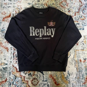 Sweatshirt från Replay - Sweatshirt från Replay med stort tryck framtill och ett broderat emblem på bröstet. Endast använd ett par gånger.