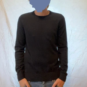 Svart stickad tröja från Pier One - En stilren svart tröja från Pier One med rund halsringning och långa ärmar. Tröjan har en klassisk passform och är tillverkad i mjuk bomull, perfekt för lager-på-lager under kyligare dagar. Aldrig använd och passar M