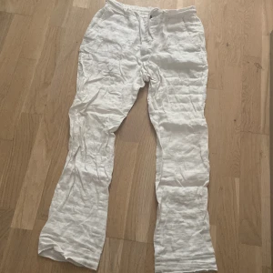 Vita linnebyxor från Zara, storlek S - Snygga och luftiga vita linnebyxor från Zara i storlek S. Byxorna har rak passform, resår i midjan och dragsko för extra komfort. Perfekta för varma dagar när du vill ha en chill och stilren look.