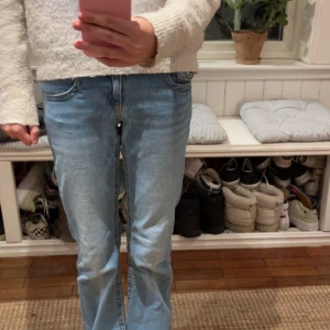 Ljusblå bootcut jeans låg midja - Säljer ett par ljusblå jeans med bootcut och låg midja. Jeansen har klassisk femficksdesign, bälteshällor och stängs med dragkedja och dubbla knappar. Snygg tvätt och skön passform, perfekta till sneakers eller boots. 