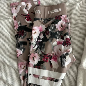 Blommiga leggings från Stronger S - Supersnygga leggings från Stronger i storlek S med blommigt mönster i. Bred resår med logga. Tillverkade i stretchigt material. Perfekta för träning eller chill. Säljer även två andra mönster! Pris kan diskuteras 