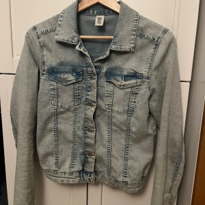 Ljusblå jeansjacka från Denim - Säljer en ljusblå jeansjacka från Denim med klassisk krage, silverfärgade knappar och två bröstfickor med lock. Jackan har lång ärm och en snygg tvättad look som ger en cool vibe. Perfekt att slänga över en hoodie eller t-shirt.💕