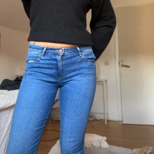 Blå bootcut jeans från Wrangler - Blå jeans från Wrangler, bootcut och låg midja. Byxorna har riktiga fickor, dragkedja och knapp framtill och Wrangler-logga på bakfickan. Jättefint skick i storlek: W28 L34💕
