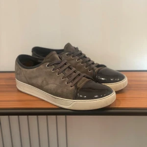 Lanvin captoe mörkgrå - Säljer ett par feta skor från lanvin i mörkgrå mocka med den kända captoen i svart lack. Storlek uk 10.5 motsvarande 45 och passar mig perfekt som själv bär 44-46. Skorna är i bra skick och det enda är att de är lite slitna på insidorna där hälen ligger vid. Men inget som påverkar hur de ser ut eller hur de känns att ha på sig. Mvh Algot.