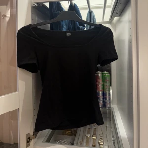 Svart T-shirt med bred urringning!! - En svart, enkel basic T- shirt från Shein med bred urringning och korta ärmar. Modellen är figurnära och passar perfekt till jeans eller kjol. Tillverkad i mjuk bomull som känns skön mot huden. Stilren och lätt att matcha med olika accessoarer.