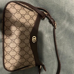 GG väska  - Snygg väska som är brun och guld! Hör av er om ni har frågor. Använd några gånger 