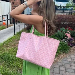 Rosa väska - Stor och rymlig ljusrosa väska med klassiskt mönster i vitt. Väskan har två långa handtag och är perfekt för att bära med sig allt man behöver. Sparsamt använd och i fint skick!