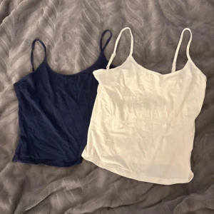2-pack linne marinblå & vit - Två stilrena linnen från shein i storlek M, ett i marinblått och ett i vitt. Båda har smala axelband och ärmlös design, perfekta för att bygga lager eller bära som de är. Materialet är mjukt och lätt bomull, vilket gör dem sköna att ha på sig under varma dagar.