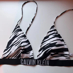 Zebramönstrad bikiniöverdel Calvin Klein - Snygg trekants-bikiniöverdel från Calvin Klein med svartvitt zebramönster💕. Den är bara andvänd en gång eftersom passformen inte passade🥰. Ställ gärna frågor🥰👍. Dock så skulle jag säga att den är lite mindre än L, skulle tippa på ungefär S/M❤️