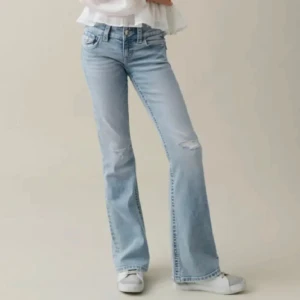 Ljusblå bootcut jeans med slitningar - Säljer ett par ljusblå bootcut jeans Från gina som jag gjort flera hål i. Finns ett hål där bak så man ser igenom lite same några fläckar men inte så tydliga! 