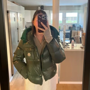Moncler jacka Dam - Superfin grön dunjacka från Moncler. Runt luvan är det även en grönt ribbat tyg! QR kod & DIST certifikat finns på sista bilden (bild 4) 💚 Jackans skick är superbra & är så gott som oanvänd, kvitto saknas. Passar XS/S i storlek! Priset kan diskuteras vid en snabb affär ☺️