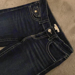 Bootcut jeans från Gina Tricot 152 - Mörkblå jeans från Gina Tricot i storlek 152. Klassisk femficksmodell med kontrastsömmar och snygga detaljer på bakfickorna. Jeansen har normal passform och är tillverkade i ett stretchigt bomullsmaterial för extra komfort.pris kan diskuteras 