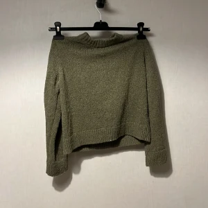 Olivgrön stickad tröja från H&M - Säljer en olivgrön stickad tröja från H&M i storlek 146/152. Tröjan har en enkel design med ribbad kant vid hals, ärmslut och nederkant. Den är långärmad och har en loose passform som gör den skön att bära under kyliga dagar.