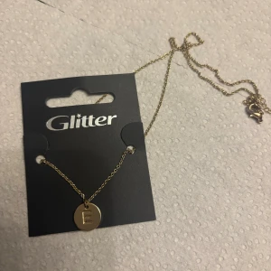 Halsband - Halsband från Glitter med bokstav E på. Helt oanvänd, nypris 85kr säljer för 30kr