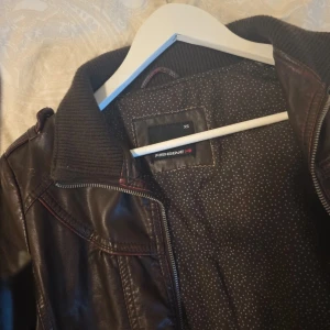 Mörkbrun skinnjacka från Fishbone XS - Snygg mörkbrun skinnjacka från Fishbone i storlek XS. Den har några slitage som symms knappt, men kan inte lägga upp då man kan ha max 5 bilder, så fråga hjärna så skickar jag alla bilderna! Passar smal XS, är själv S men den e liten in chest area, vilket e varför jag säljer den 😔. Priset kan diskuteras men jag står inte för frakten! 