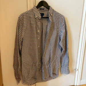 Skjorta från Gant - Mörkblå/beige/vit rutig skjorta med en bröstficka. 